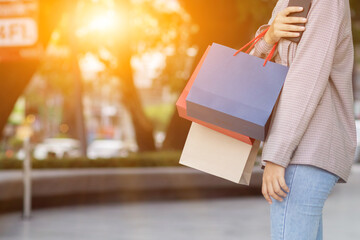 A young woman holding a shopping bag after going shopping for discounted items in a department store as the New Year's holiday approaches, there is a promotion on sale. shopping concept