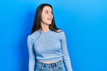 Fototapeta na wymiar Young brunette teenager wearing casual sweater looking away to side with smile on face, natural expression. laughing confident.