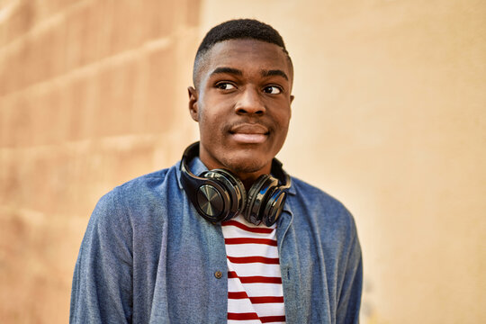 Young african american man with relaxed expression using headphones at the city.