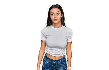 Fototapeta premium Young hispanic girl wearing casual white t shirt relaxed with serious expression on face. simple and natural looking at the camera.