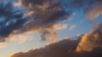 Ciel aux couleurs nacrées, pendant le coucher du soleil.  Les reflets du soleil sous ces petits cumulus confèrent une teinte sublime à ces nuages