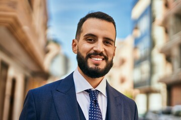 Fototapeta premium Young businessman smiling happy standing at the city.
