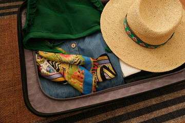 Suitcase preparation for vacation.Summer vacation plan. Summer clothes, straw hats and colorful...