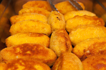 Kiev fried chicken meatballs close-up with tongs for taking food.