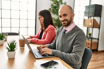 Two hispanic business workers smiling happy working at the office.