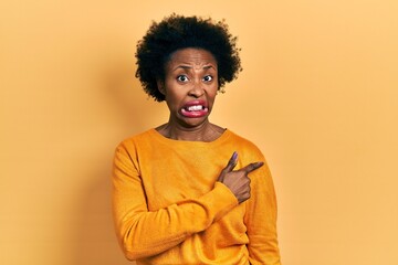 Fototapeta na wymiar Young african american woman wearing casual clothes pointing aside worried and nervous with forefinger, concerned and surprised expression