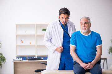 Obraz premium Old male patient visiting young male doctor