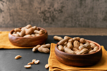 Image of bunch of peanuts in a bowl on a slate surface