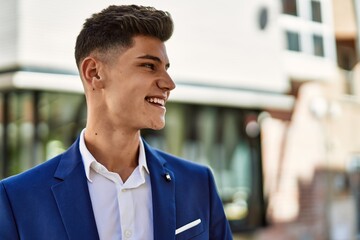 Fototapeta premium Young man smiling confident wearing suit at street