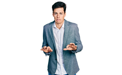 Young hispanic man wearing business clothes disgusted expression, displeased and fearful doing...