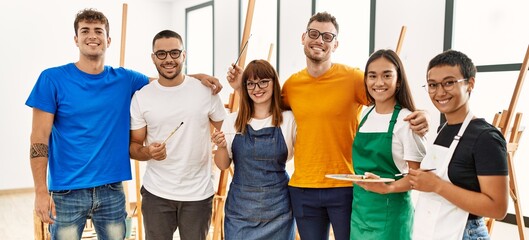 Group of people hugging and smiling happy standing at art studio.