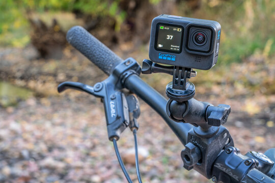 Fort Collins, CO, USA - October 15, 2021: GoPro Hero 10 black, waterproof action camera mounted with a popular articulated RAM mount on mountain bike handlebars against river landscape.