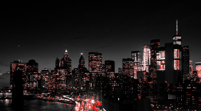 Red lights of Manhattan night skyline shining against a black and white cityscape of downtown New York City © deberarr