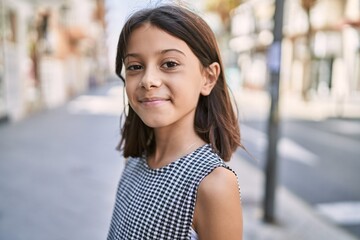 Young hispanic girl smiling outdoor at the town