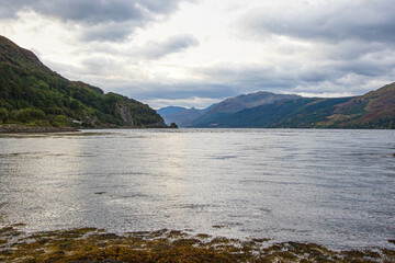 Medieval Eilean Donan Castle in Scotland. minimalist Scottish landscape of a misty morning on a calm, Loch Fada lake on the Isle of Skye, Scotland.