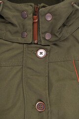 Close-up of pockets and buttons on a green winter jacket. Women's demi-season jacket. 