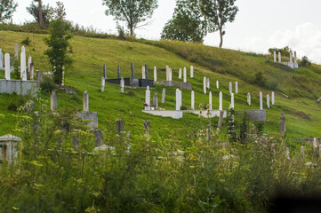Stary cmentarz nagrobki na wzniesieniu na zielonej trawie - obrazy, fototapety, plakaty