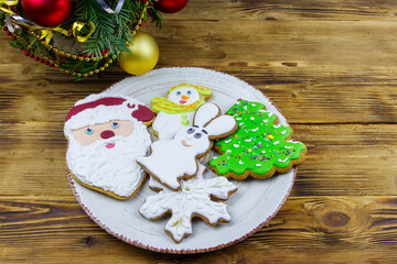 Christmas gingerbread cookies in a plate and Christmas decoration on a wooden table