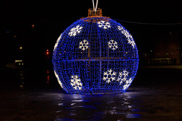 Fototapeta premium Large illuminated Christmas bauble on a city square