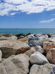 Fototapeta na wymiar Vertical view of the Mediterranean sea hitting rocks on the beach.