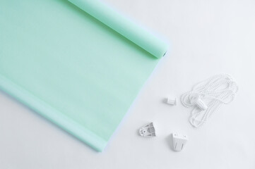 Green roller blinds blinds with plastic fastening on white background.