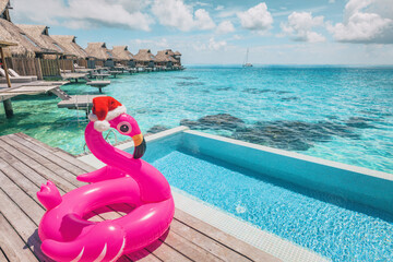 Luxury Christmas getaway swimming pool resort with santa hat flamingo pool float. July in winter...