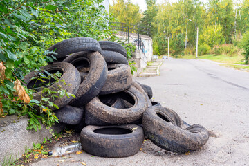 a bunch of old tires, garbage by the road. environmental pollution and technical household waste, the fight for ecology and clean yards and streets