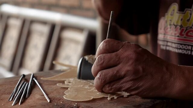 The process of making a Wayang kulit. Traditional form of puppet-shadow play in Yogyakarta, Java, Indonesia. Leather craftsmen making Wayang Kulit. Making of puppets.