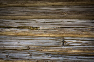 Wooden logs of an old house. Close-up. Weathered natural gray wood texture. Background. Horizontal photo