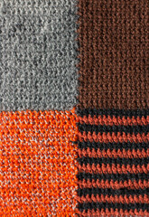 Brown, gray and orange background with striped pattern. Close-up collage. The structure of a knitted, soft, hand-woven woolen fabric. Macro.