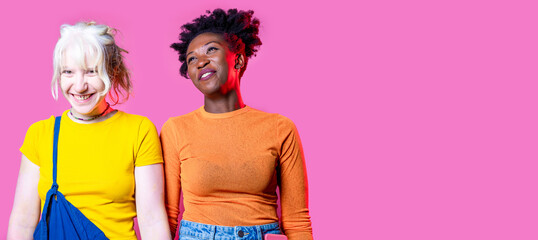 Two young diverse multicultural caucasian and black women best friends posing isolated background...