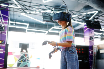 Girl in vr glasses holds joysticks in her hands