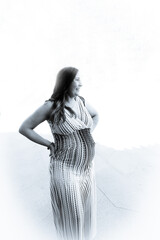 Seven month pregnant woman outdoors in multi colored striped dress