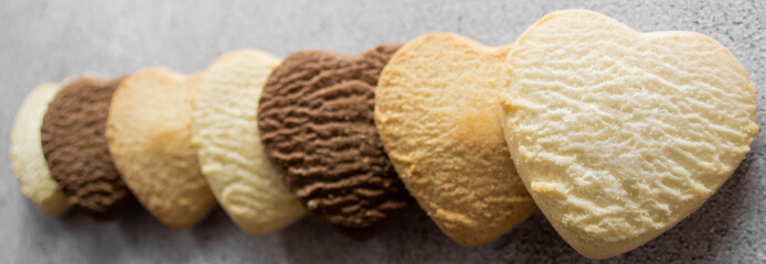 Banner with cookies in the shape of a heart: vanilla, lemon, chocolate. Gray background, copy space