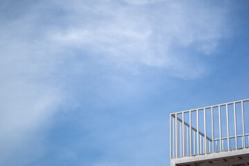 The deck is made of steel painted white. against a bright sky background