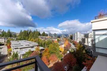 Colorful Fall view of Univercity Highlands on Burnaby Mountain, BC, seen from a neighborhood rooftop patio.