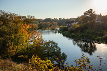 View from the hill on the autumn bank of the river. Autumn landscape colors.