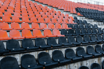 Fototapeta premium Empty stands and seats for fans and fans in the open-air stadium. Lack of fans during the pandemic.