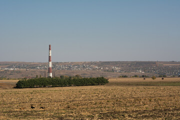 Thermal power plant pipe towering over power lines
