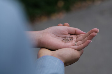 the hands of the bride and groom hold the rings