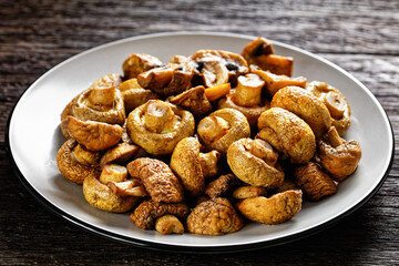 grilled juicy mushrooms on a plate, top view