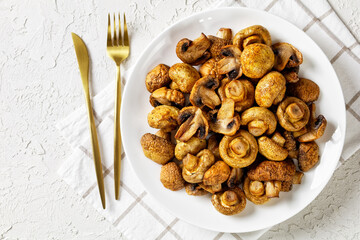 grilled juicy mushrooms on a plate, top view