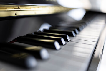 Fototapeta na wymiar A close up of a keyboard of a black grand piano