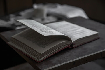 An old book lies in an abandoned hospital. An old open book. Dirty pages. Forgotten place.