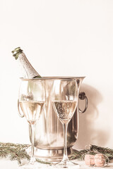 Christmas holiday still life; bottle and two glasses of champagne on white background, vertical picture