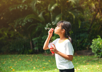 Girl is in a field trips and playing blowing bubbles in the park, Outside school education concept