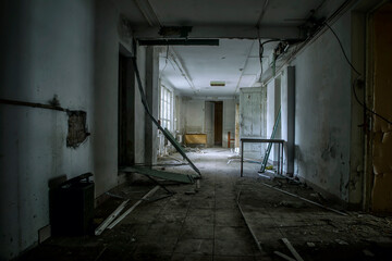 Scary empty dark corridor in an abandoned building. Shabby walls. The play of light and shadows in an abandoned house. Broken doors. An old abandoned hospital. The interior of an abandoned house.