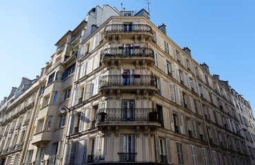 The facade of traditional French house with typical balconies and windows. Paris.