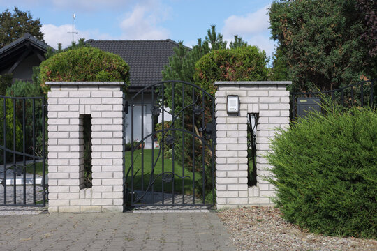Modern brick fence and metal wicket. Intercom at the entrance to the property..