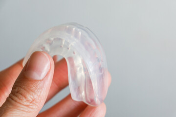 transparent mouth guard made of silicone, for straightening teeth in children, in a girl's hand, in...